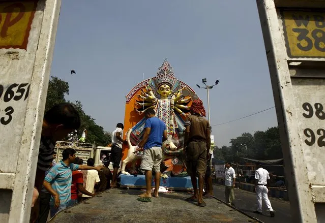 Devotees prepare to unload an idol of the Hindu goddess Durga for immersion into the Ganges river after the end of the Durga Puja festival in Kolkata, India, October 25, 2015. (Photo by Rupak De Chowdhuri/Reuters)