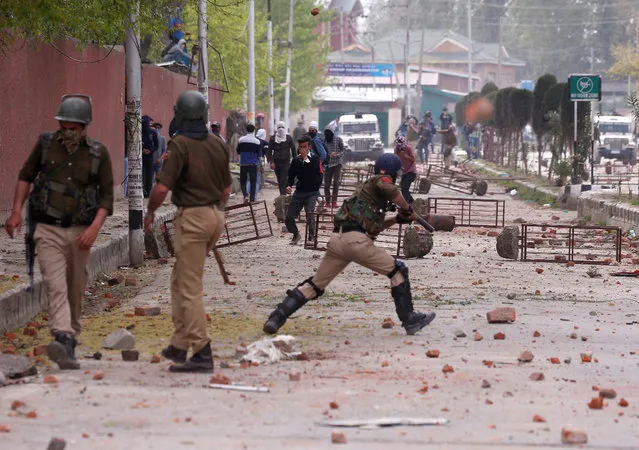 Students hurl stones towards Indian police during a protest against the recent killings in Kashmir, outside a college in Srinagar April 5, 2018. (Photo by Danish Ismail/Reuters)