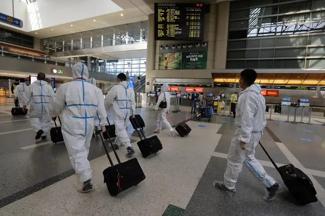 A flight crew walks through Tom Bradley international terminal at LAX airport, as the global outbreak of the coronavirus disease (COVID-19) continues, in Los Angeles, California, U.S., November 23, 2020. (Photo by Lucy Nicholson/Reuters)