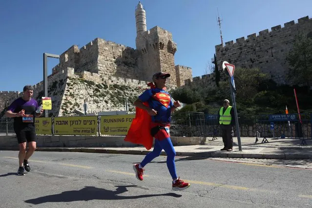 A participant wearing a Superman outfit attends the International Jerusalem Marathon outside the Old City of Jerusalem, on March 17, 2023. (Photo by Gil Cohen-Magen/AFP Photo)