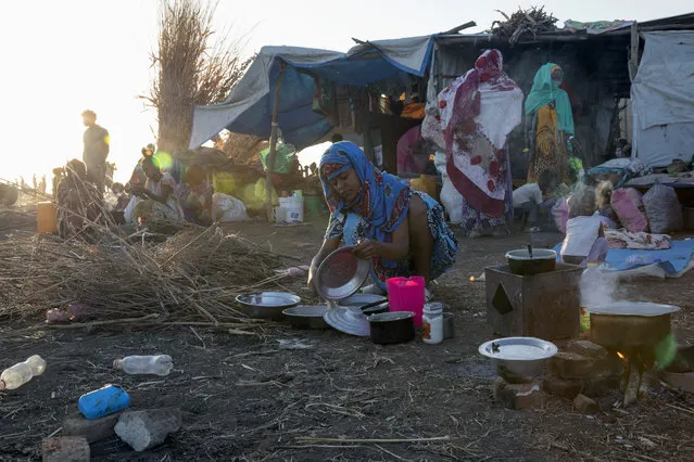A Tigray refugee woman who fled the conflict in the Ethiopia's Tigray prepares breakfast for her family at Hamdeyat Transition Center near the Sudan-Ethiopia border, eastern Sudan, Thursday, December 3, 2020. Ethiopian forces on Thursday blocked people from the country's embattled Tigray region from crossing into Sudan at the busiest crossing point for refugees, Sudanese forces said. (Photo by Nariman El-Mofty/AP Photo)