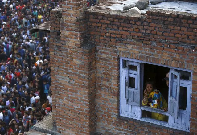 A woman looks out from the window of a house as devotees gather to observe the Bisket festival at Bhaktapur April 14, 2015. (Photo by Navesh Chitrakar/Reuters)