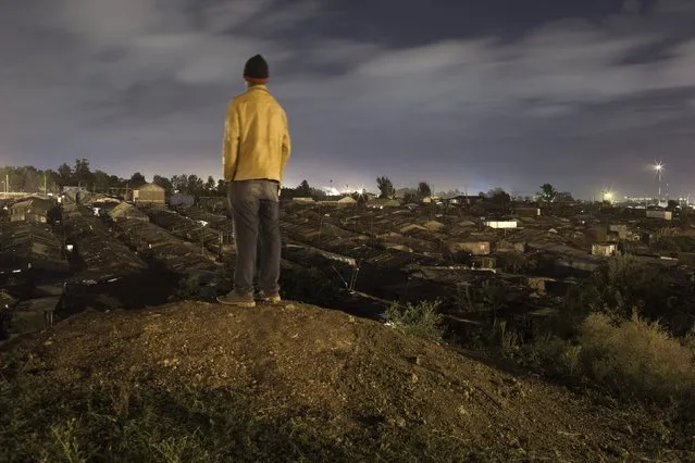 A man stands on a hilltop overlooking Korogocho in Nairobi, Kenya, April 24, 2015. (Photo by Siegfried Modola/Reuters)