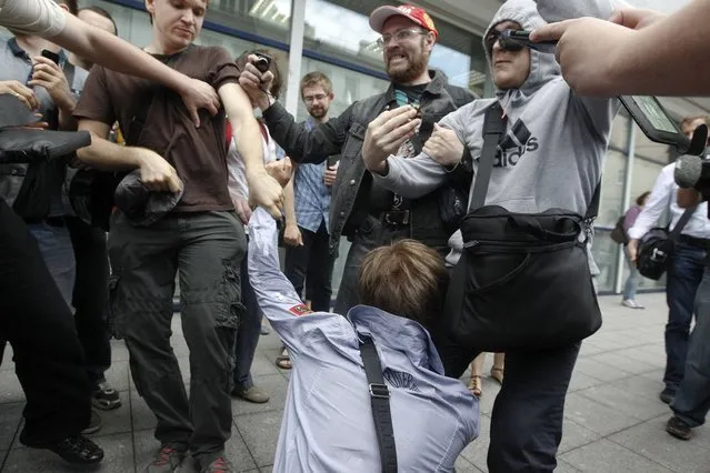 People attack a gay rights activist during a protest against a proposed new law termed by the State Duma, the lower house of Parliament, as “against advocating the rejection of traditional family values” in central Moscow June 11, 2013. (Photo by Maxim Shemetov/Reuters)