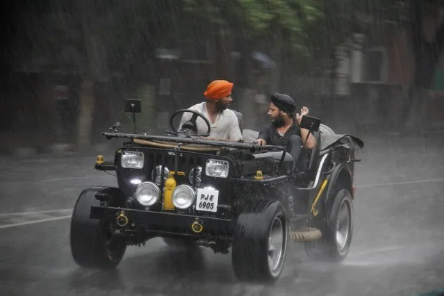Sikh men ride a jeep during a heavy rain shower in the northern Indian city of Chandigarh June 13, 2013. India's weather office has forecast an average monsoon in the country in 2013. (Photo by Ajay Verma/Reuters)