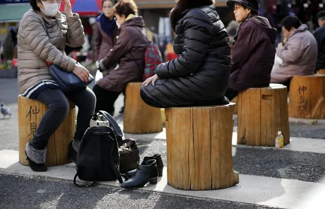 People sit to rest on a street at Tokyo's Sugamo district, an area popular among the Japanese elderly, in Tokyo January 14, 2015. Japanese Prime Minister Shinzo Abe's cabinet approved on Wednesday a record $812 billion budget for the coming fiscal year while cutting new borrowing for a third straight year in a bid to balance growth and fiscal reform. (Photo by Toru Hanai/Reuters)