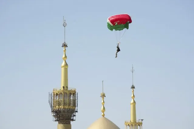 A paratrooper flies down over the mausoleum of the late revolutionary founder Ayatollah Khomeini during Iranian Army Day parade just outside Tehran, Iran, Tuesday, April 18, 2023. (Photo by Vahid Salemi/AP Photo)