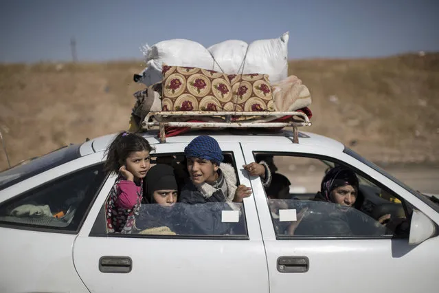 Displaced people in a convoy of cars drive away from Mosul, Iraq, Friday, November 4, 2016. (Photo by Felipe Dana/AP Photo)