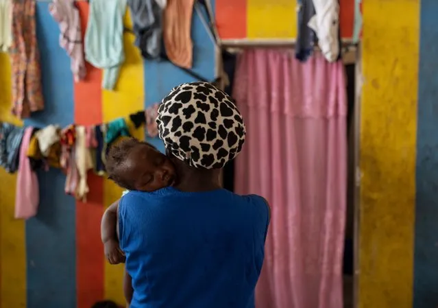 A woman holds her baby at a shelter for people displaced by gang violence in Port-au-Prince, Haiti, Tuesday, May 30, 2023. (Photo by Ariana Cubillos/AP Photo)