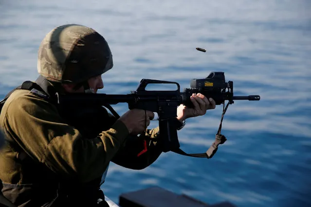 An Israeli officer fires a rifle as he takes part in a drill simulating the targeting of an infiltrated enemy vessel and the evacuation of a patrol boat, in the Mediterranean Sea off the coast of Ashdod, southern Israel November 8, 2016. (Photo by Amir Cohen/Reuters)