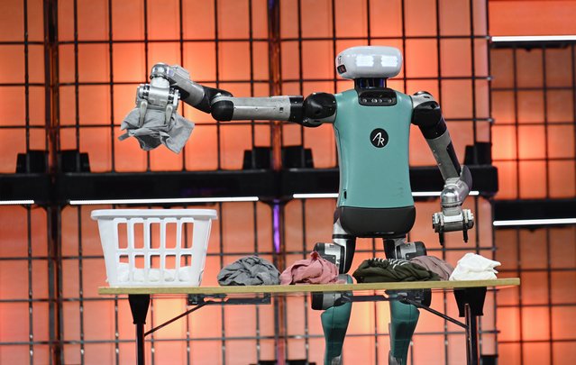 Digit the robot handles clothing as Peggy Johnson, CEO Agility Robotics, is in conversation with Nicholas Thompson, CEO The Atlantic, on “Meet your new robot co-worker” presenting Digit, the 72kg, 1.75m bipedal bot at Center Stage during the second day of Web Summit on November 13, 2024 in Lisbon, Portugal. The annual conference brings together founders and CEOs of technology companies, as well as policymakers, to discuss the future of the Web. This year Web Summit, the annual conference that brings together founders and CEOs of technology companies, as well as policymakers, to discuss the future of the Web, runs from November 11 to November 14. The 2024 event announced that has officially sold out its Lisbon flagship event with more than 70,000 attendees, a record breaking 3,000 exhibiting companies, 1,000 investors and 2,000 global media. This year's Web Summit marks the comeback of Paddy Cosgrave, CEO and co-founder of the event, who had resigned in 2023 and was replaced by Katherine Maher. Ms. Maher left after three months and, in April 2024, Cosgrave decided to return as CEO. (Photo by Horacio Villalobos#Corbis/Getty Images)