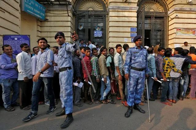 Riot police control people queueing to exchange old high denomination bank notes at a bank in Old Delhi, India, November 11, 2016. (Photo by Cathal McNaughton/Reuters)