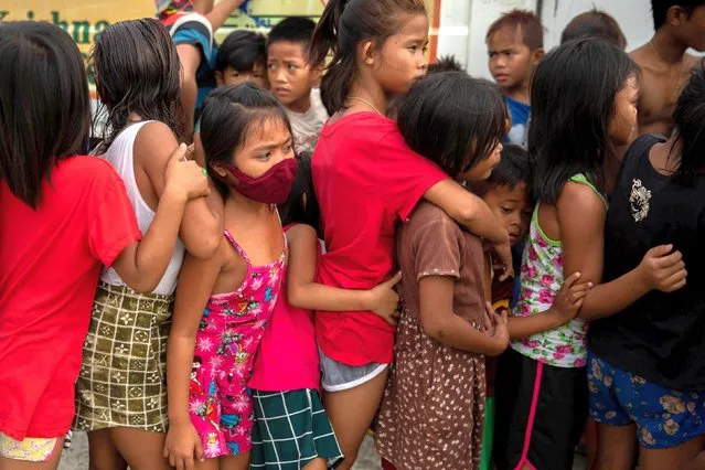 Children queue for free food from a relief program, amid the coronavirus disease (COVID-19) outbreak, in a slum area in Manila, Philippines on January 21, 2021. (Photo by Eloisa Lopez/Reuters)