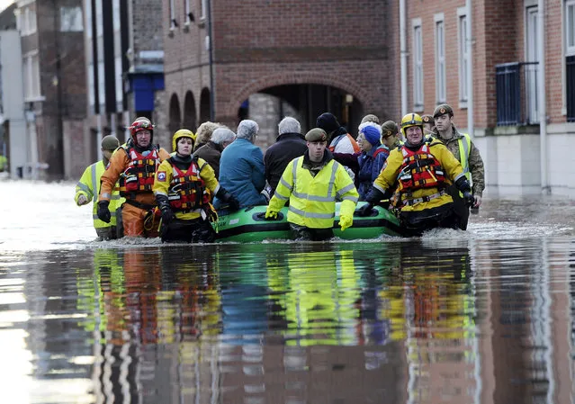 Members of the army and rescue teams help evacuate people from flooded properties after they became trapped by rising floodwater when the River Ouse bursts its banks in York city center Sunday, December 27, 2015. Homes were evacuated, cars were submerged and boats were brought in to help bring people to safety Saturday as parts of England, Scotland and Wales faced severe flooding caused by repeated heavy rains. (Photo by John Giles/PA via AP Photo)