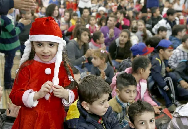 Iraqi and Syrian refugee children celebrate Christmas during a ceremony hosted by His Beatitude Archbishop Michel Qasarji, Diocese of Chaldeans in Babdaa, Lebanon December 19, 2015. (Photo by Mohamed Azakir/Reuters)