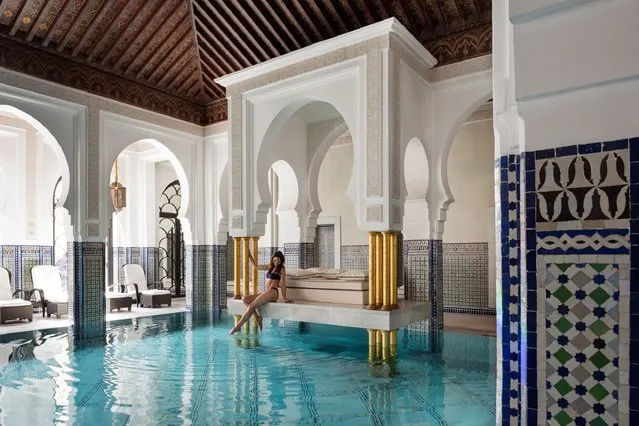 World's Greatest Swimming Pools: La Mamounia, Marrakech, Morocco. Below you, glazed Moroccan tiles shimmer in blues and greens. Above you, a dark wood ceiling vaults into a panel of stained-glass windows, with designs reflecting the ornate arches surrounding the pool. Around you, gilded columns frame the swim-up daybed, crowned by a marble platform. As traditional lanterns emit an amber sheen on the walls, you might ask: Is this heaven? (From $432). (Photo by La Mamounia)