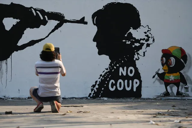 A man takes a picture of a graffiti by Thai artist Mue Bon against the military coup in Myamar in a street in Bangkok, Thailand, February 6, 2021. (Photo by Chalinee Thirasupa/Reuters)