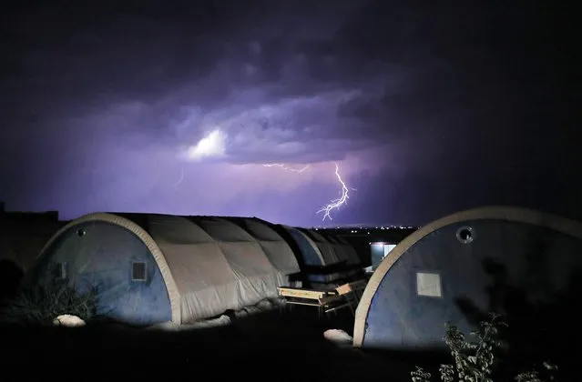 This picture taken on October 16, 2022 shows a view of lightning strikes in the sky during a thunderstorm in al-Yaman camp for people internally-displaced by conflict north of Syia's rebel-held northwestern city of Idlib. (Photo by Omar Haj Kadour/AFP Photo)