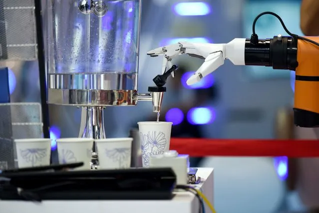 A robot arm demonstrates how to collect a cup of water at the 2018 World Robot Conference in Beijing on August 15, 2018. (Photo by Wang Zhao/AFP Photo)