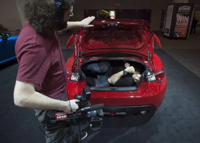 A member of the media tests the size of the trunk of the Scion FR-S sports coupe at the 2015 Canadian International Auto Show in Toronto on Thursday, February 12, 2015. (Photo by Darren Calabrese/AP Photo/The Canadian Press)