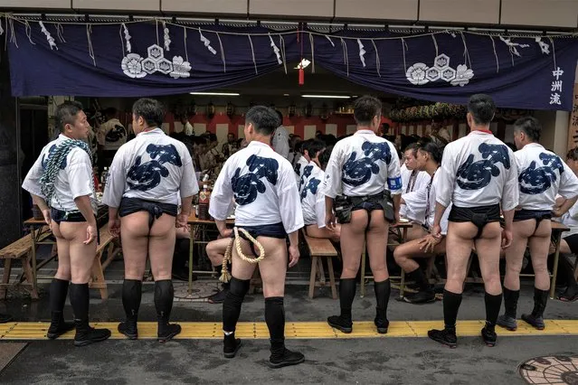 Men in loincloths stand in front of a resturant in Fukuoka, Japan on July 13, 2023. (Photo by Marko Djurica/Reuters)