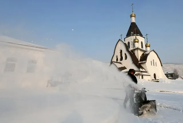 A monk removes snow in a compound of the Uspensky male monastery during preparations for the Orthodox Christmas night service in the vicinity of the Siberian city of Krasnoyarsk, Russia, January 6, 2016. (Photo by Ilya Naymushin/Reuters)