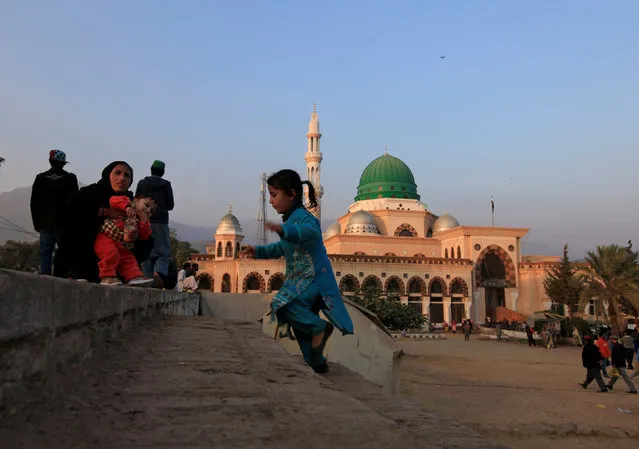 A girl plays near her mother as they're visiting the shrine of Bari Imam in Islamabad, Pakistan December 2, 2016. (Photo by Faisal Mahmood/Reuters)