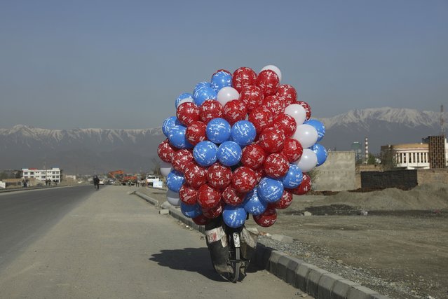 An Afghan balloon vendor riding his bicycle looks for customers in Kabul, Afghanistan, Wednesday, April 7, 2021. (Photo by Rahmat Gul/AP Photo)