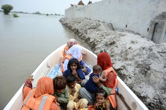 Rescue officials evacuate victims on a boat from flooded areas in Noora Nath, Pakpattan district, Punjab province, Pakistan, 23 August 2023. Around 100,000 people have been evacuated from flooded villages in Pakistan's Punjab province, according to emergency services on 23 August. The province faces the largest flood in 35 years along the Sutlej River, caused by water discharge upstream from neighboring India, provincial Relief Commissioner Nabeel Javed said. Rains and floods leave significant human and material losses in South Asian countries every year, especially during the monsoon period between June and September. (Photo by Faisal Kareem/EPA/EFE)