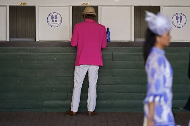 A man places a bet before the 147th running of the Kentucky Derby at Churchill Downs, Saturday, May 1, 2021, in Louisville, Ky. (Photo by Charlie Riedel/AP Photo)