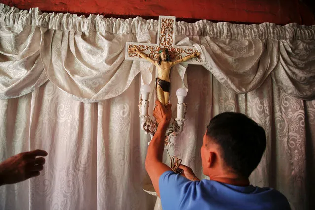 A crucifix is taken down from the room where the coffin of Florjohn Cruz was placed as his remains are taken for his funeral in Manila, Philippines October 30, 2016. (Photo by Damir Sagolj/Reuters)