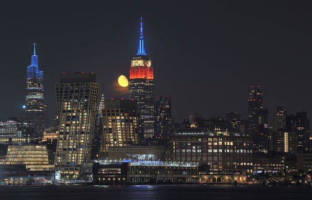 A 78 percent waning gibbous moon rises behind the Empire State Building lit in red, white, and blue to mark Labor Day weekend in New York City on September 3, 2023, as seen from Hoboken, New Jersey. (Photo by Gary Hershorn/Getty Images)