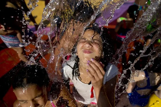 A girl refreshes herself at a park on a hot day in Buenos Aires, Argentina, Friday, January 22, 2016. Temperatures reached 36 degrees Celsius during the day as residents looked for ways to cool down. (Photo by Natacha Pisarenko/AP Photo)