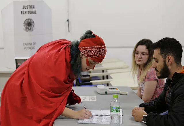 A woman prepares to vote in the presidential runoff election in Sao Paulo, Brazil, Sunday, October 28, 2018. Brazilian voters decide who will next lead the world's fifth-largest country, the left-leaning Fernando Haddad or far-right rival Jair Bolsonaro. (Photo by Nelson Antoine/AP Photo)