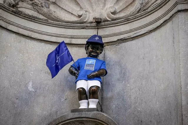 A picture shows the Manneken Pis statue with a NATO costume on the occasion of the NATO Summit in Brussels, on June 14, 2021. (Photo by Juliette Bruynseels/AFP Photo)