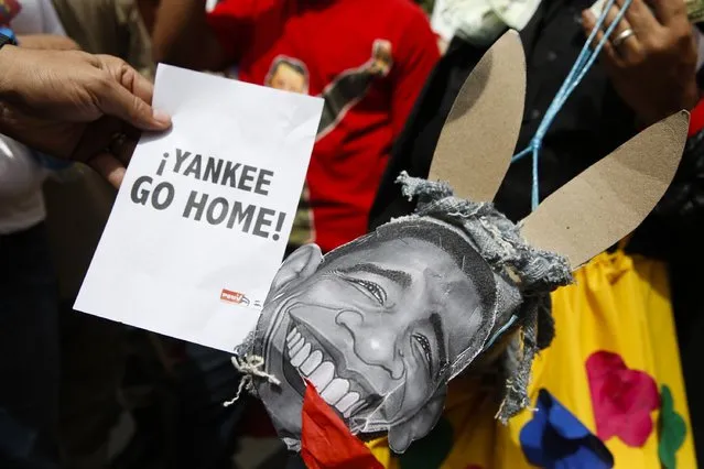 Supporters of Venezuela's President Nicolas Maduro hold a placard depicting U.S. President Barack Obama during a rally against imperialism, in Caracas March 15, 2015. Venezuela's parliament granted President Maduro decree powers on Sunday for the rest of 2015 in a move he says is to defend the country from U.S. meddling but opponents decry as evidence of autocracy. The placard reads, “Yankee go home”. (Photo by Carlos Garcia Rawlins/Reuters)