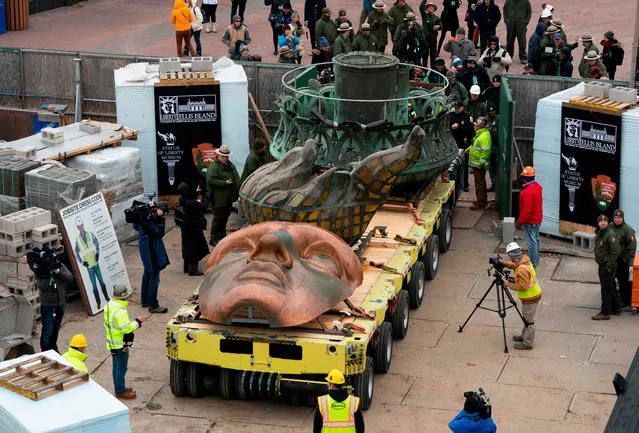 Workers transport the Statue of Liberty original torch along with a replica of the statue' s face to its permanent home in the new Statue of Liberty Museum November 15, 2018 in New York City. (Photo by Don Emmert/AFP Photo)