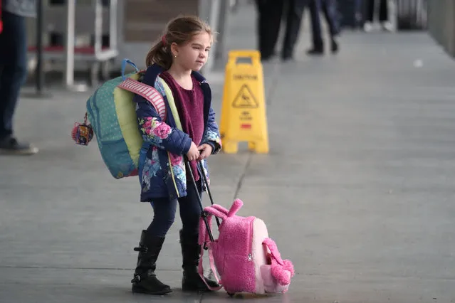 A girl holds her luggage outside the Delta air terminal at LaGuardia Airport in New York, U.S., November 20, 2018. (Photo by Shannon Stapleton/Reuters)