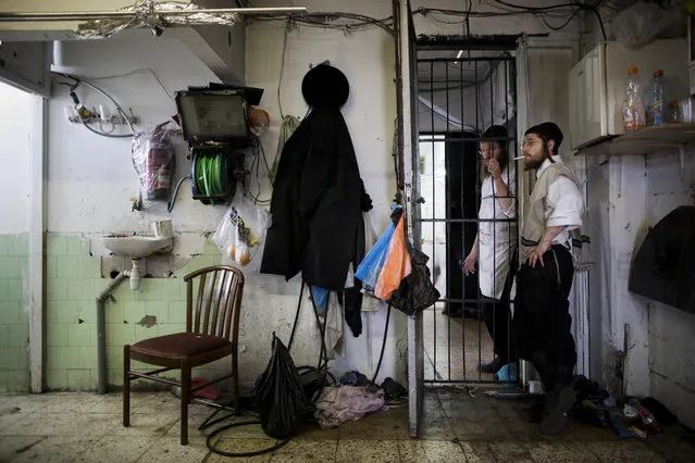 Ultra-Orthodox Jews smoke a cigarette as they take break during baking of special matzoh, a traditional handmade Passover unleavened bread, at a bakery in Bnei Brak near Tel Aviv, Israel. Thursday, April 10, 2014. (Photo by Oded Balilty/AP Photo)