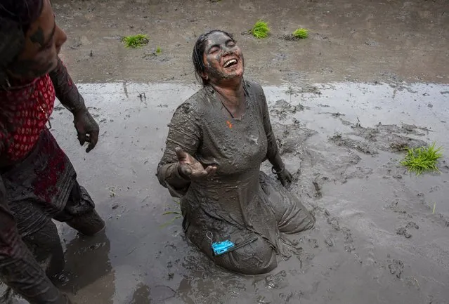 People splash mud water in a paddy field on National Paddy Day in Tokha village, on the outskirt of capital Kathmandu, Nepal, 29 June 2021. Nepal is celebrating National Paddy Day with various events on 29 June. On this day, known as Asar Pandra, farmers begin the annual rice planting season and mark the day with various festivities such as preparing rice meals with muddy water, mud being a symbol for a prosperous season. Sixty percent of Nepal's agriculture industry relies on monsoon rain while 40 percent is carried out through irrigation. Agriculture is a major contributor to the country's GDP. (Photo by Narendra Shrestha/EPA/EFE)