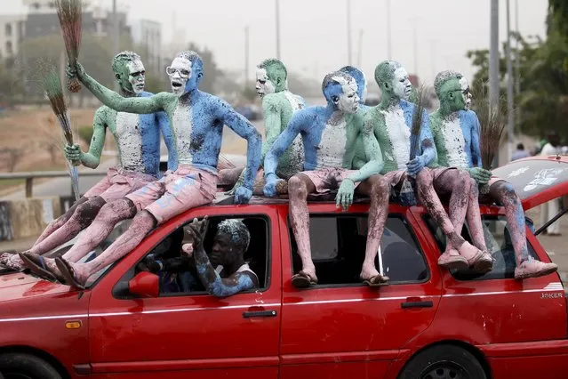 Supporters with painted bodies sit on a vehicle as they celebrate outside the office of the All Progressives Congress (APC) party after president-elect Muhammadu Buhari won the presidential election, along a street in the capital Abuja, April 1, 2015. (Photo by Akintunde Akinleye/Reuters)