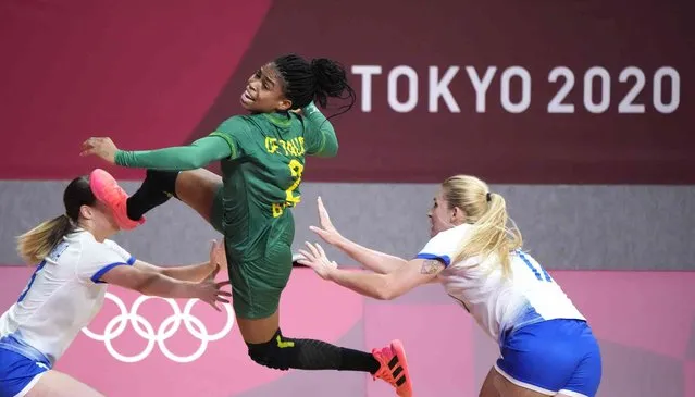 Brazil's Bruna de Paula, centre, scores during the women's preliminary round group B handball match between Russian Olympic Committee and Brazil at the 2020 Summer Olympics, Sunday, July 25, 2021, in Tokyo, Japan. (Photo by Sergei Grits/AP Photo)