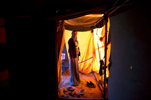 In this Monday, March 16, 2015 photo, Syrian refugee Feedah Ali, 18, who is four months pregnant, poses for a portrait inside her tent at an informal settlement near the Syrian border, on the outskirts of Mafraq, Jordan. Pregnant refugee women living in these settlements are among the most vulnerable of the hundreds of thousands of Syrians who have found shelter in Jordan. (Photo by Muhammed Muheisen/AP Photo)