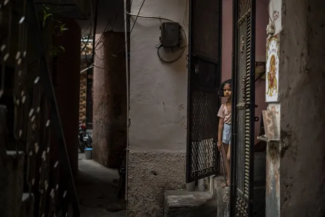 A young girl stands at the entrance of her house next to the house of a 9-year-old girl from the lowest rung of India's caste system who according to her parents and protesters, was raped and killed earlier this week, in New Delhi, India, Thursday, August 5, 2021. (Photo by Altaf Qadri/AP Photo)