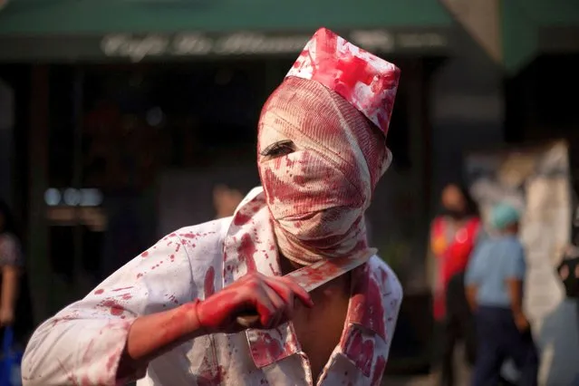 A person dressed as a zombie gestures during the annual Zombie Walk in Mexico City, Mexico on October 22, 2022. (Photo by Quetzalli Nicte-Ha/Reuters)
