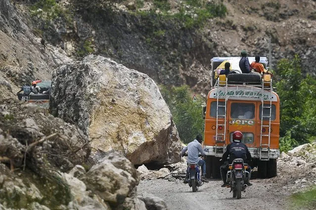 Drivers negotiate a mountainside road cluttered with debris from a landslide triggered by Saturday's 7.2-magnitude earthquake, in Rampe, Haiti, Wednesday, August 18, 2021. (Photo by Matias Delacroix/AP Photo)