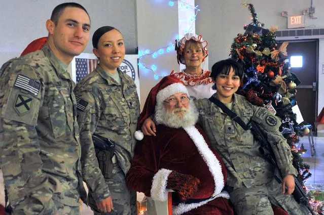 Soldiers with the NATO-led International Security Assistance Force (ISAF) pose with Santa Claus during a special meal on Christmas Day at a military base in Kabul on December 25, 2013. NATO forces are withdrawing from Afghanistan after more than a decade of fighting the Taliban, but negotiations have stalled on a security accord that would allow some US and NATO troops to stay after 2014. (Photo by Noorullah Shirzada/AFP Photo)