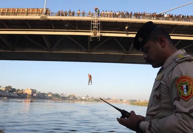 An Iraqi army cadet participates in “the leap of faith”, from a bridge as part of their training, in Baghdad, Iraq on December 15, 2023. (Photo by Ahmed Saad/Reuters)