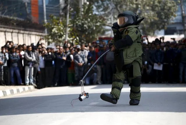 A member of the army's bomb disposal team carries a suspicious object after a bomb scare outside the Singha Durbar office complex that houses the Prime Minister's office and other ministries, in Kathmandu, Nepal March 1, 2016. The scare was later found to be a false alarm. (Photo by Navesh Chitrakar/Reuters)