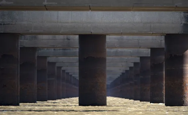 In this July 29, 2021 file photo, the pillars of the massive Rosario-Victoria Bridge are exposed during a drought affecting the Parana River near Rosario, Argentina. At the port city of Santa Fe the river registered a level of 22 centimeters, the lowest in 50 years. (Photo by Victor Caivano/AP Photo/File)